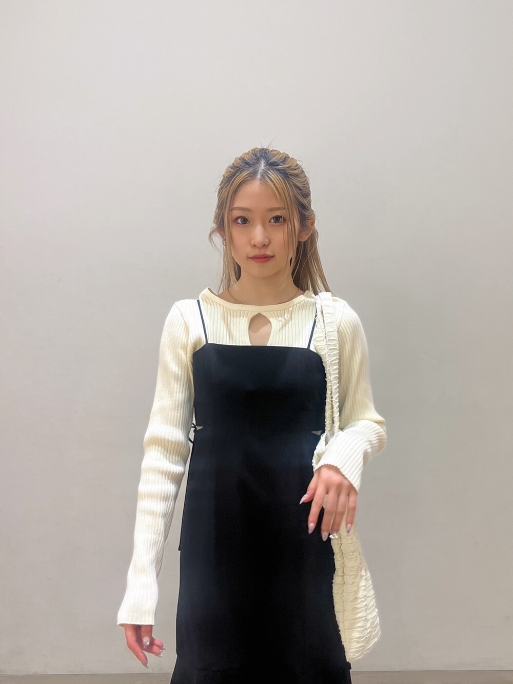 ホワイト系のニット/セーター、ブラック系のワンピース、ホワイト系のトートバッグを着用したレディースの春コーディネートの5枚目の写真