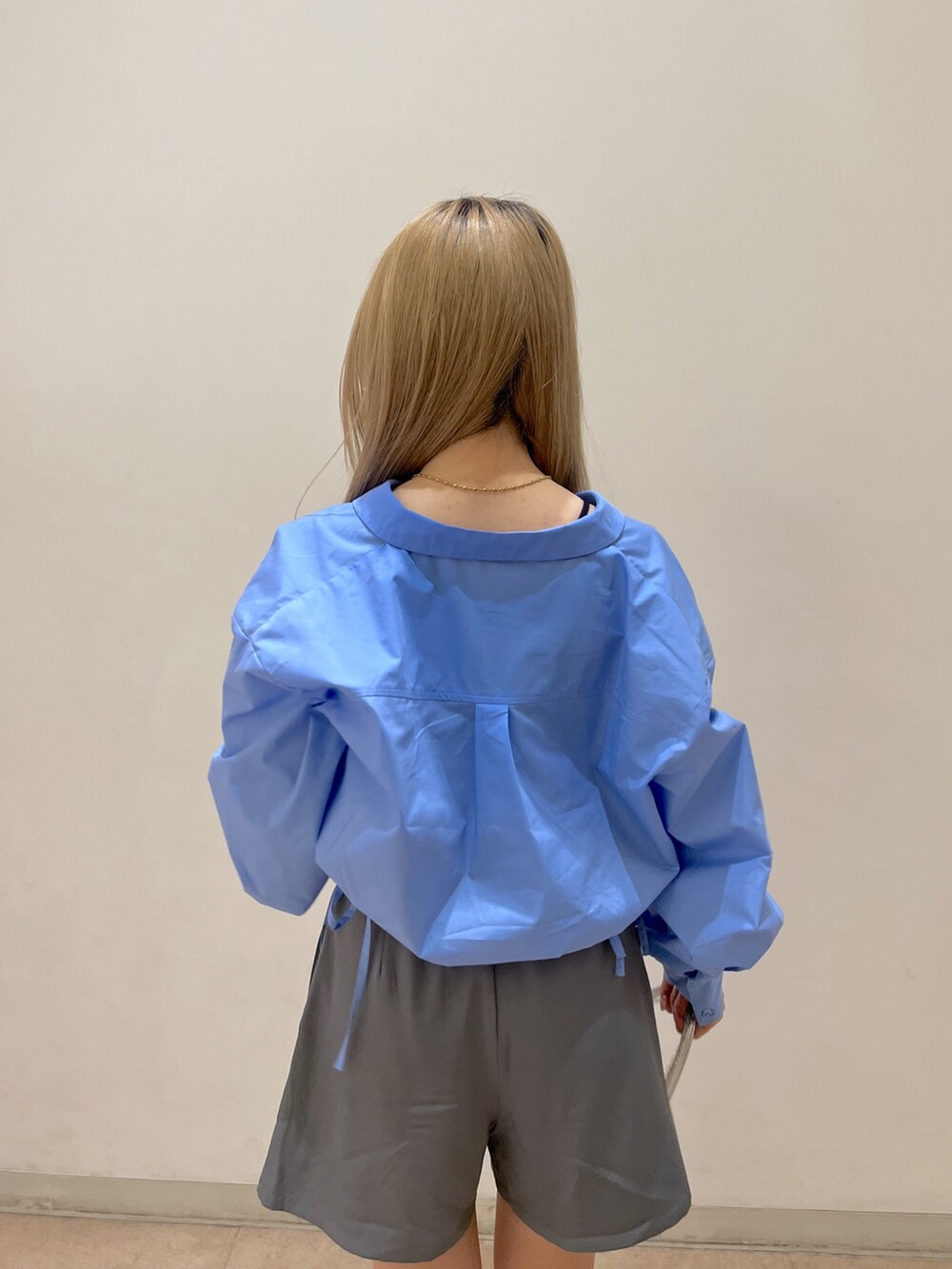 ブルー系のシャツ/ブラウス、グレー系のスカート、シルバー系のショルダーバッグを着用したレディースの春コーディネートの7枚目の写真