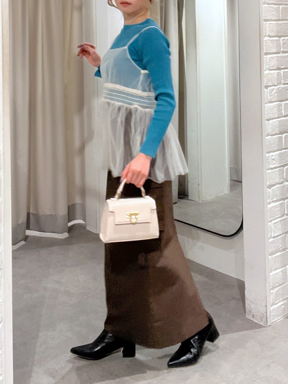 ブラウン系のスカート、ホワイト系のシャツ/ブラウス、ホワイト系のショルダーバッグを着用したレディースの冬コーディネートの6枚目の写真