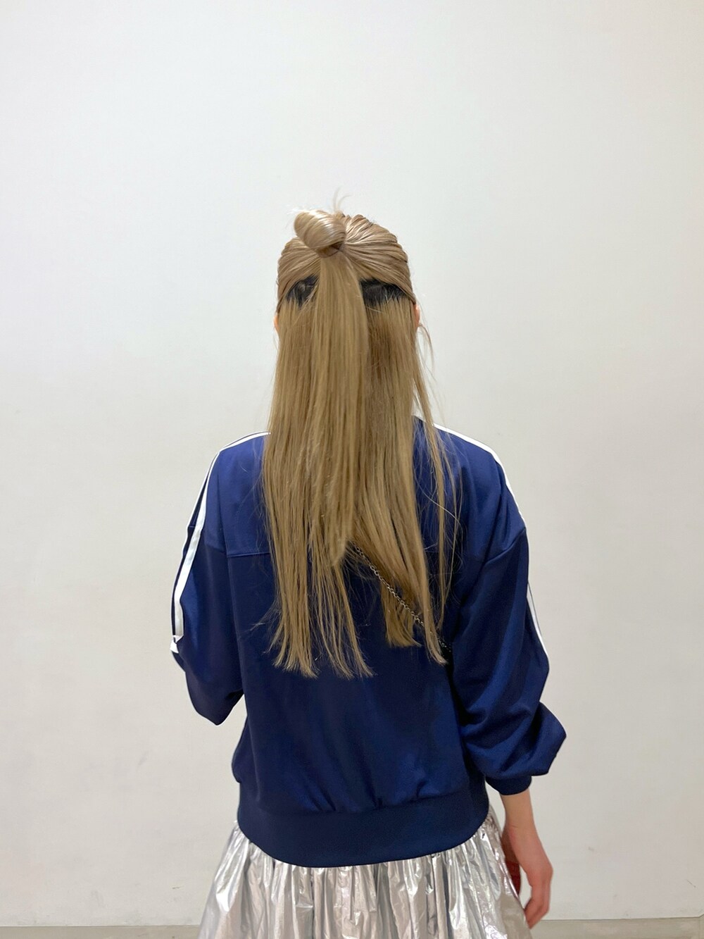 ブルー系のブルゾン、ブラック系のショルダーバッグ、シルバー系のスカートを着用したレディースの春コーディネートの7枚目の写真