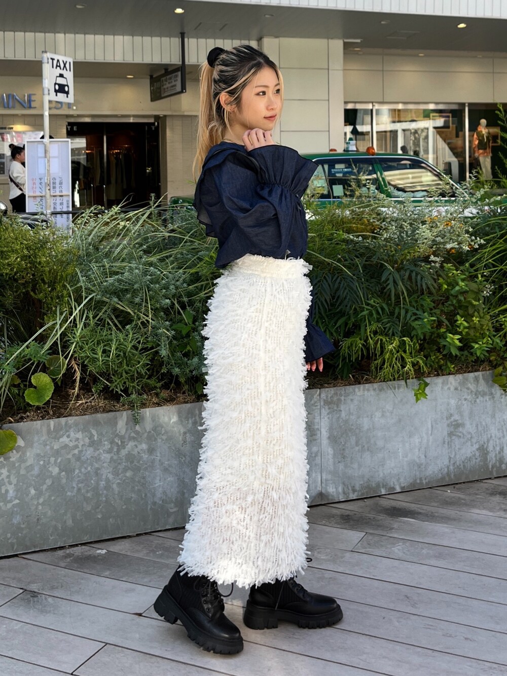 ホワイト系のスカート、ブルー系のシャツ/ブラウス、ブラック系のブーツを着用したレディースの秋コーディネートの4枚目の写真