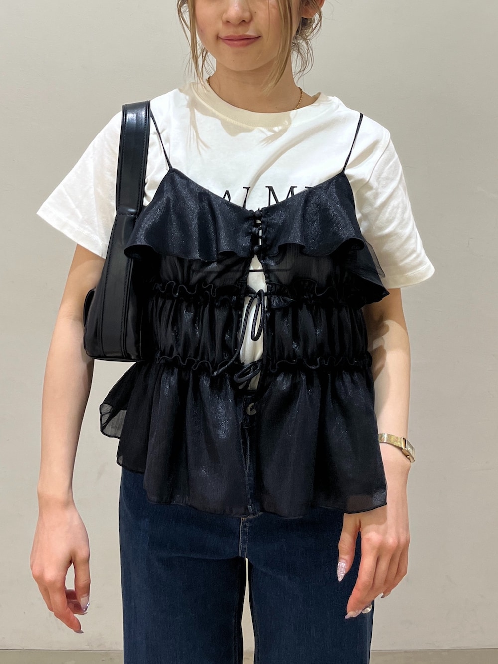 ブラック系のショルダーバッグ、ブラック系のシャツ/ブラウス、ホワイト系のTシャツ/カットソーを着用したレディースの春コーディネートの4枚目の写真