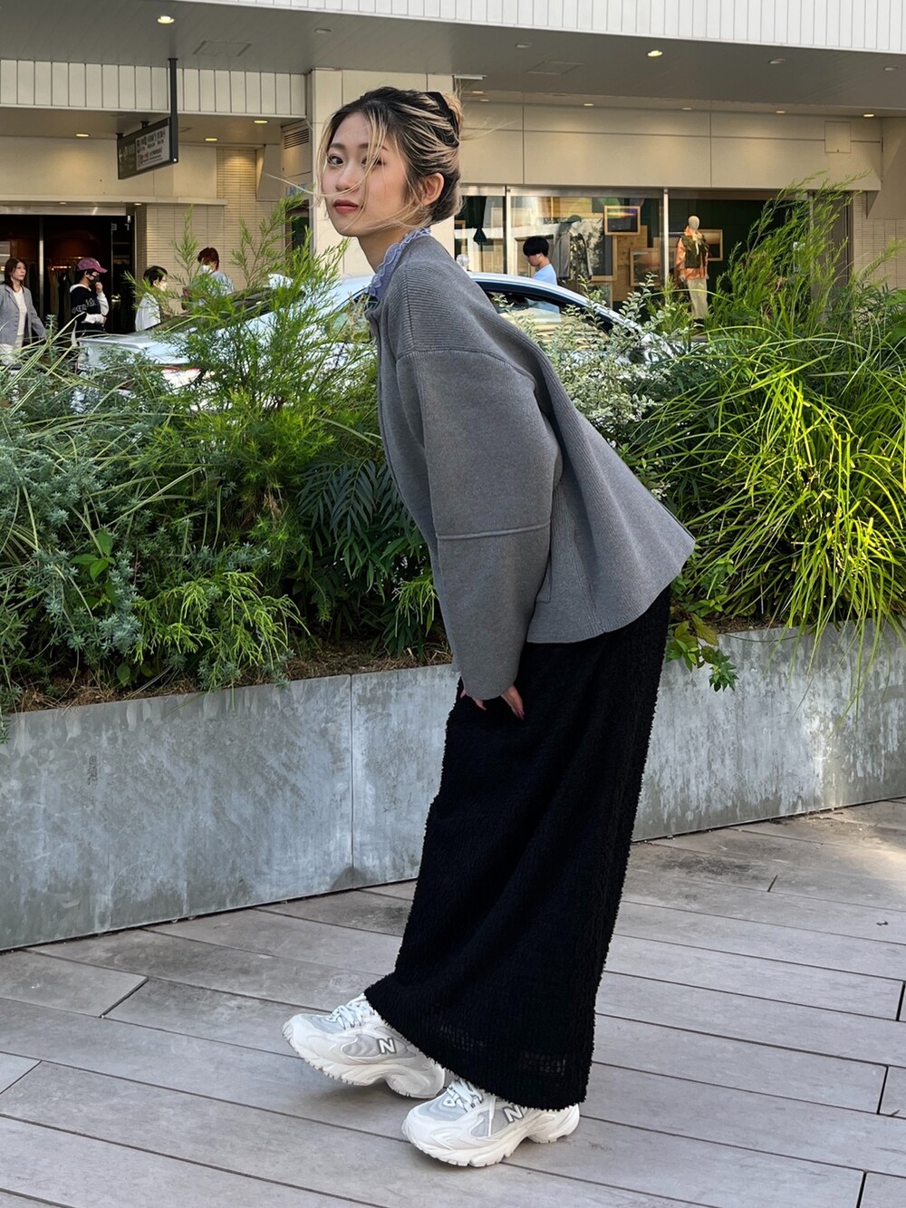 グレー系のカーディガン/ボレロ、ブラック系のスカート、ホワイト系のスニーカーを着用したレディースの秋コーディネートの3枚目の写真