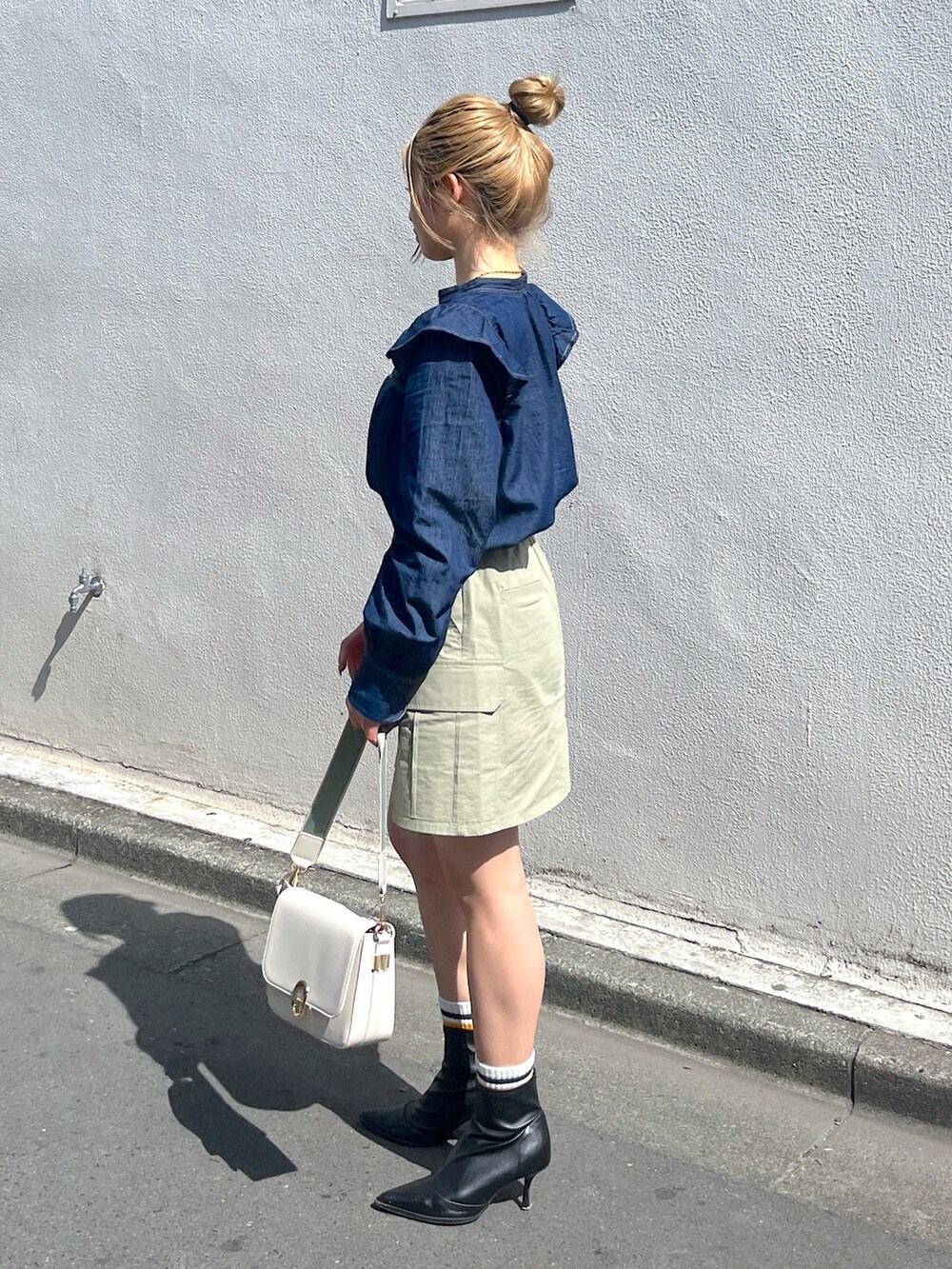 グリーン系のスカート、ホワイト系のショルダーバッグ、ブルー系のシャツ/ブラウスを着用したレディースの春コーディネートの3枚目の写真