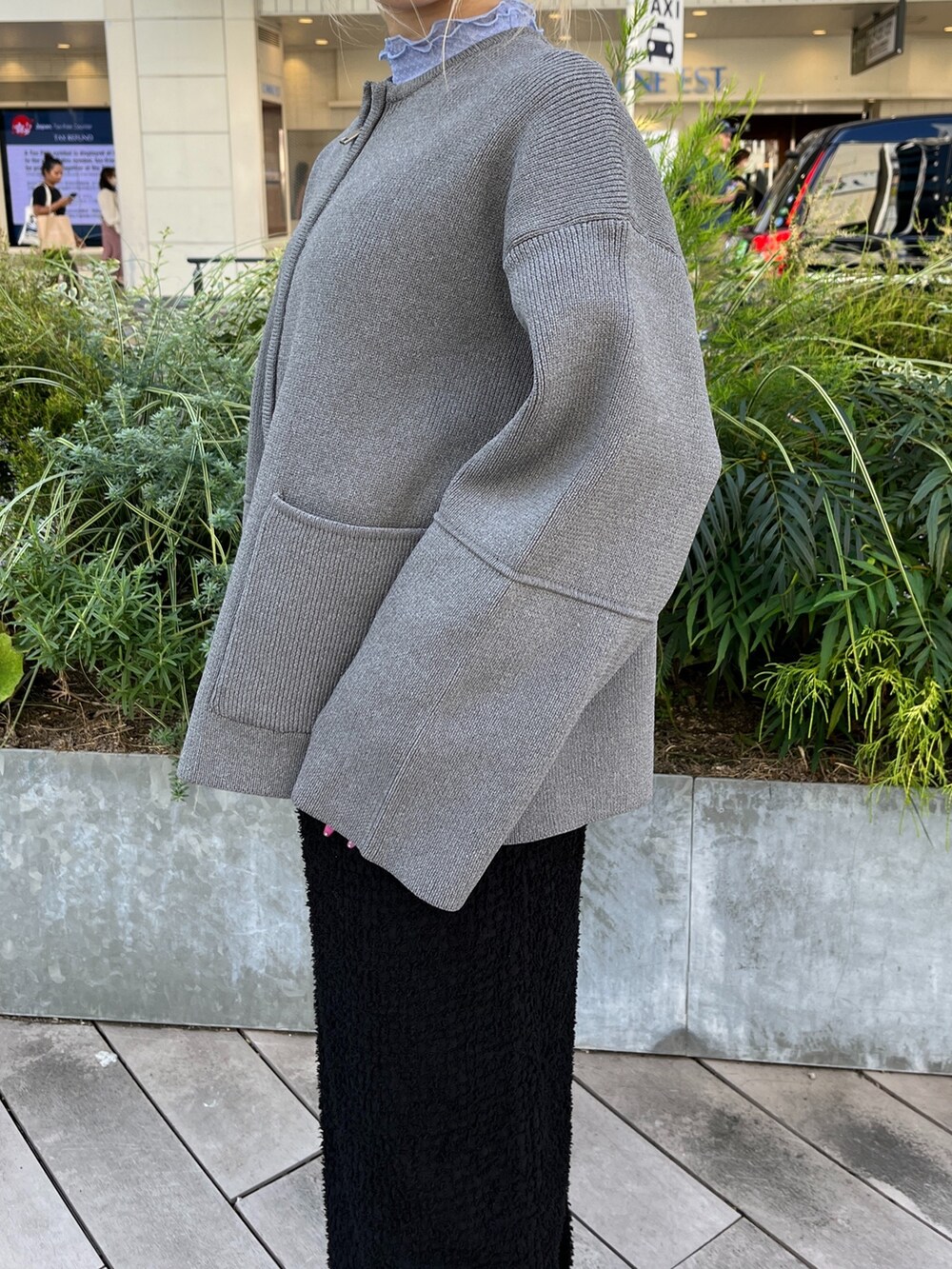 グレー系のカーディガン/ボレロ、ブラック系のスカート、ホワイト系のスニーカーを着用したレディースの秋コーディネートの8枚目の写真