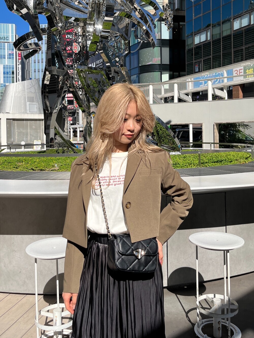 ブラック系のショルダーバッグ、ホワイト系のTシャツ/カットソー、ブラウン系のテーラードジャケットを着用したレディースの秋コーディネートの6枚目の写真