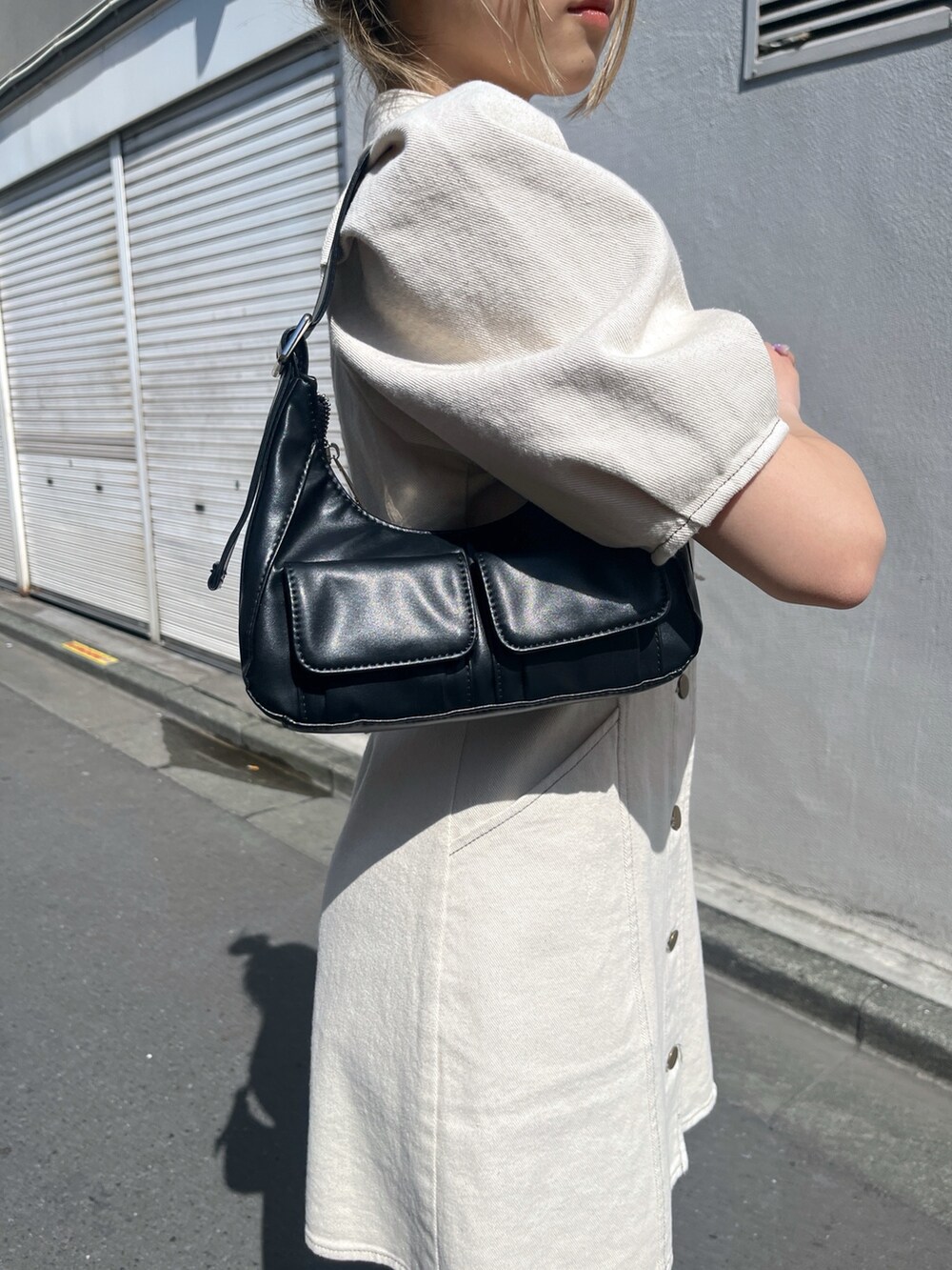 ブラック系のショルダーバッグ、ホワイト系のワンピースを着用したレディースの春コーディネートの10枚目の写真