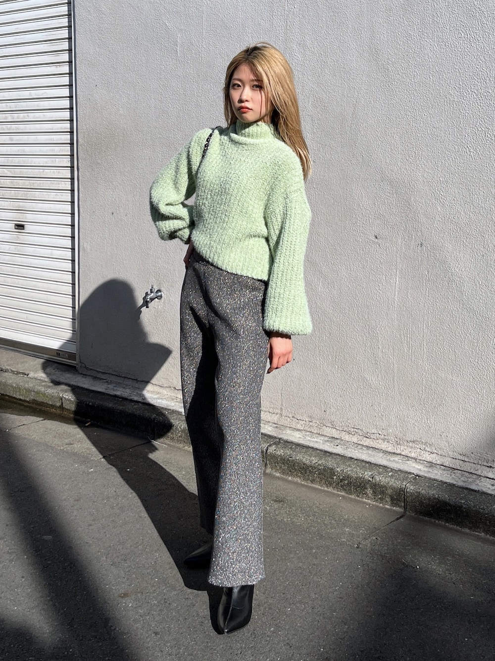 ブラック系のブーツ、ブラック系のその他パンツ、グリーン系のニット/セーターを着用したレディースの冬コーディネートの2枚目の写真