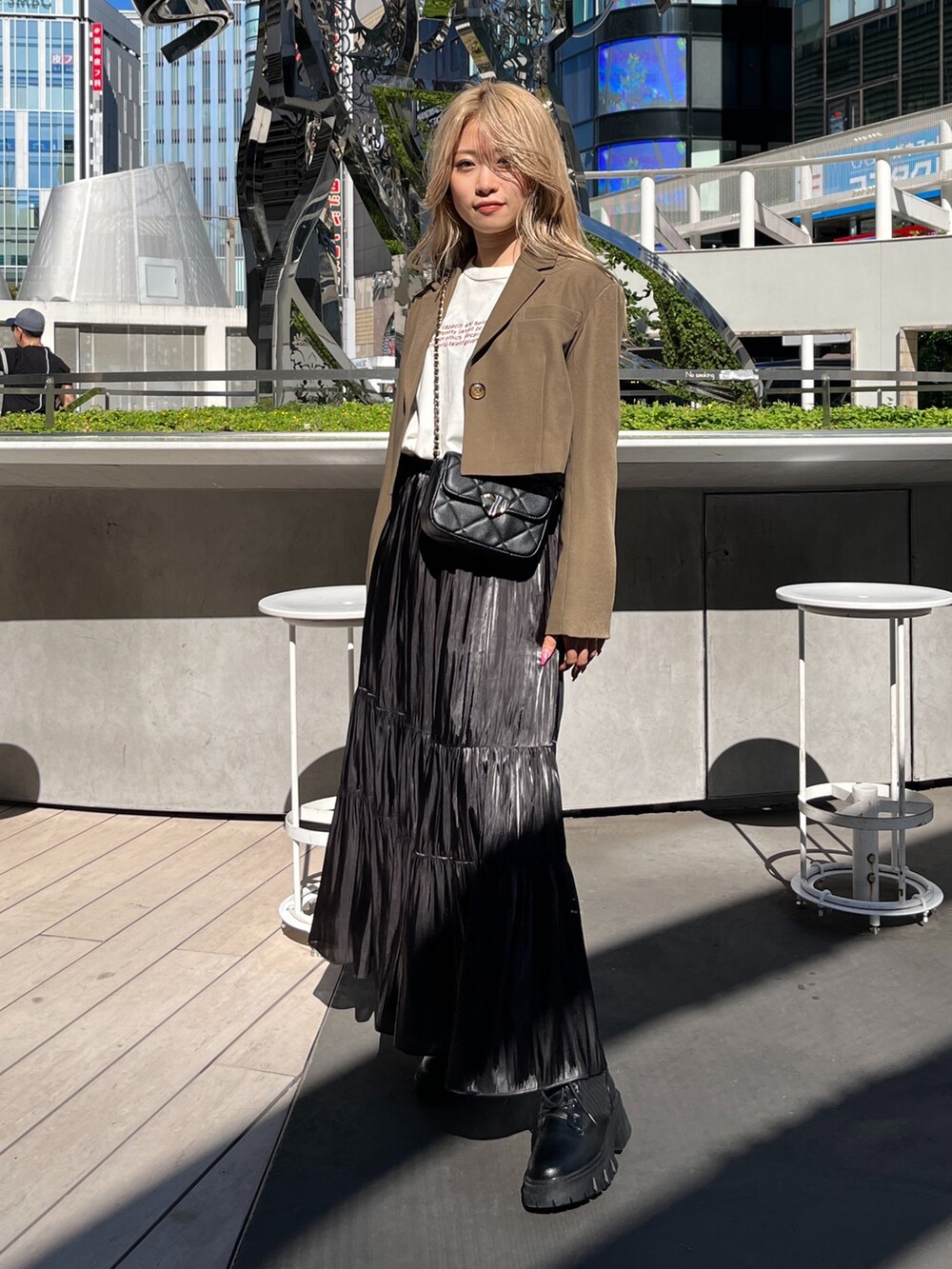 ブラック系のショルダーバッグ、ホワイト系のTシャツ/カットソー、ブラウン系のテーラードジャケットを着用したレディースの秋コーディネートの2枚目の写真