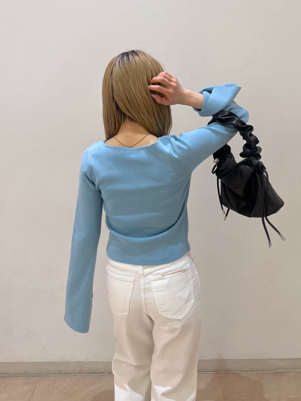 ホワイト系のデニムパンツ、ブラック系のショルダーバッグ、ブラック系のパンプスを着用したレディースの春コーディネートの5枚目の写真