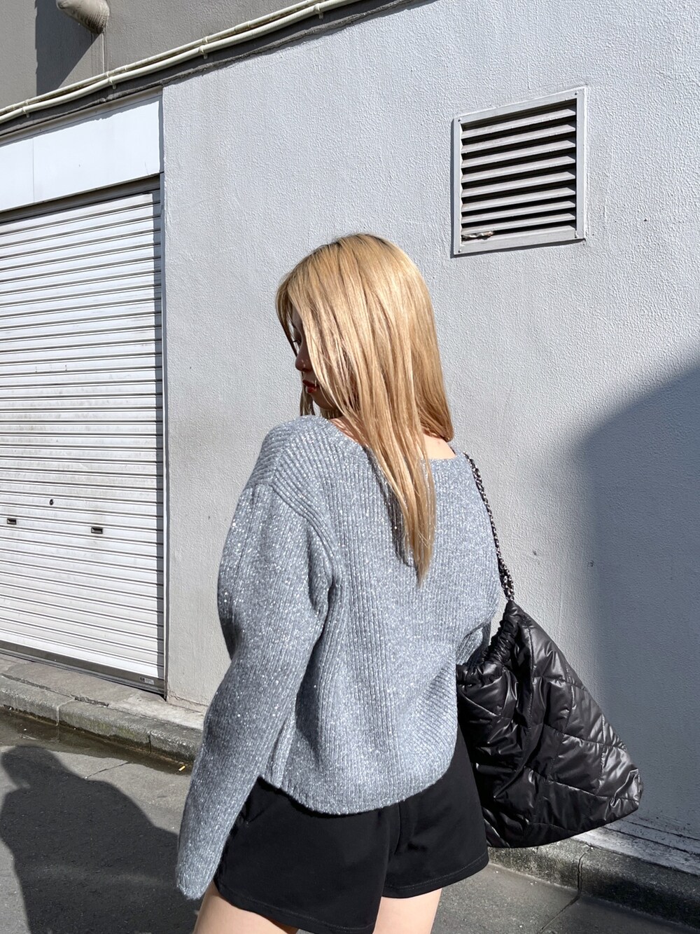 ブラック系のその他パンツ、ブラック系のブーツ、ブラック系のトートバッグを着用したレディースの冬コーディネートの6枚目の写真