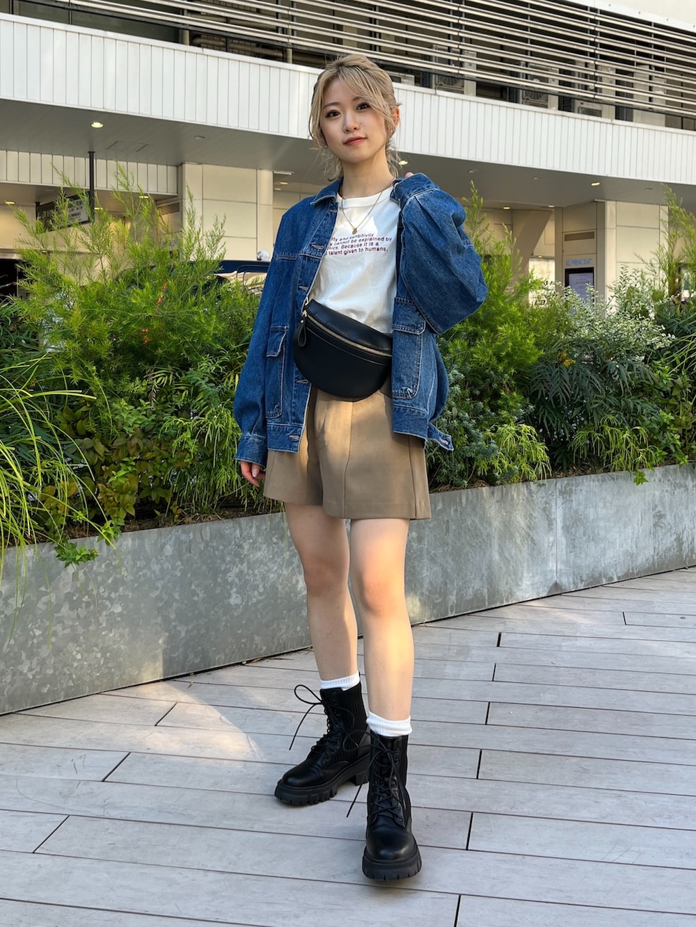 ブルー系のデニムジャケット、ホワイト系のTシャツ/カットソー、ブラック系のボディバッグ/ウエストポーチを着用したレディースの秋コーディネートの2枚目の写真