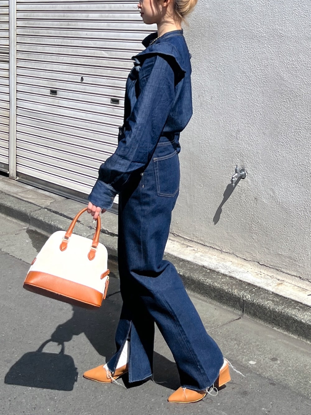 ブルー系のシャツ/ブラウス、ブルー系のデニムパンツ、ブラウン系のショルダーバッグを着用したレディースの春コーディネートの4枚目の写真