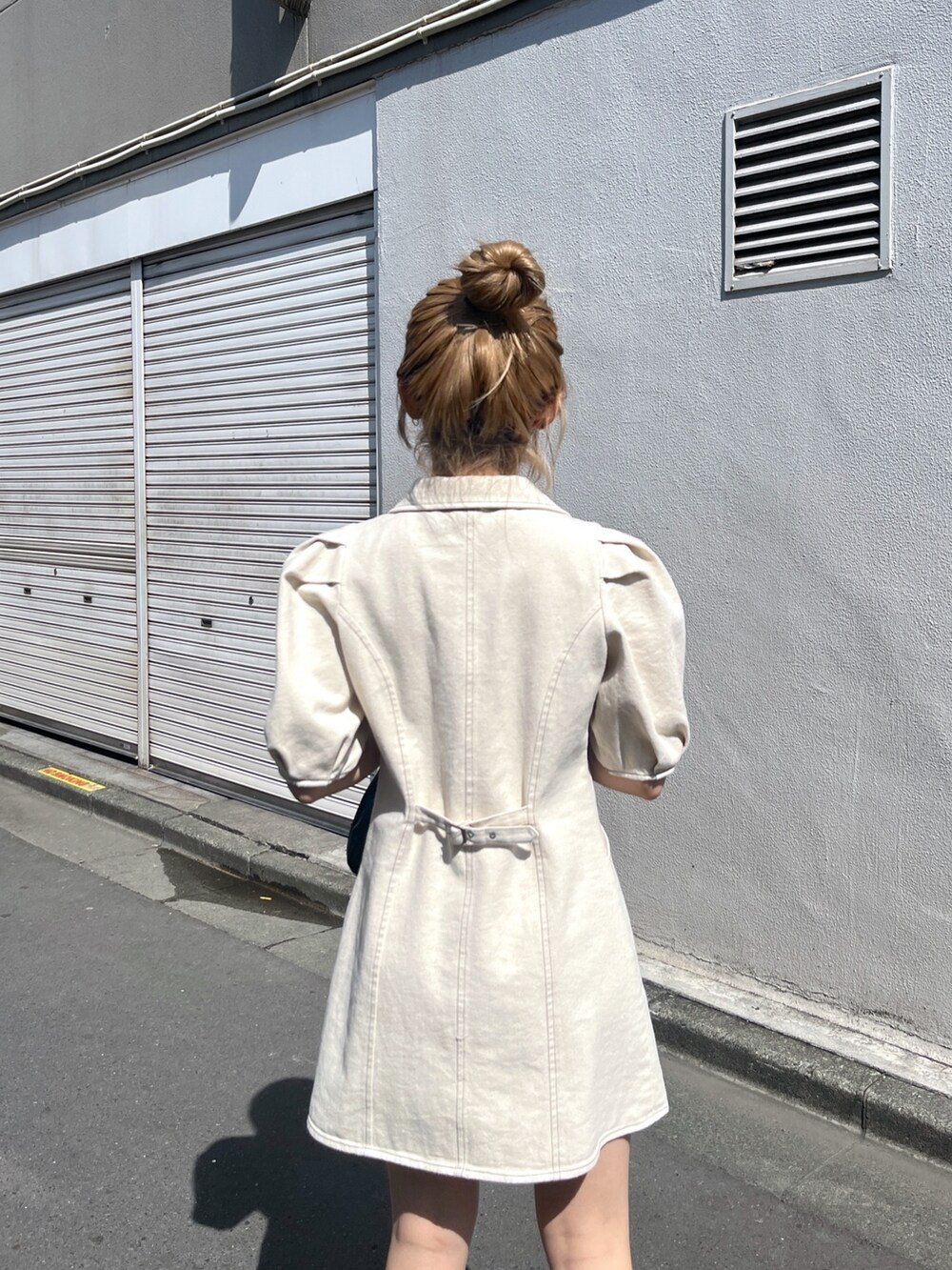 ブラック系のショルダーバッグ、ホワイト系のワンピースを着用したレディースの春コーディネートの5枚目の写真