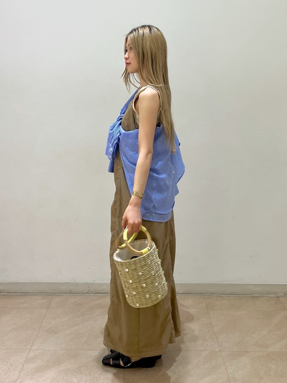 ブルー系のシャツ/ブラウス、ベージュ系のワンピース、ホワイト系のタンクトップを着用したレディースの春コーディネートの2枚目の写真