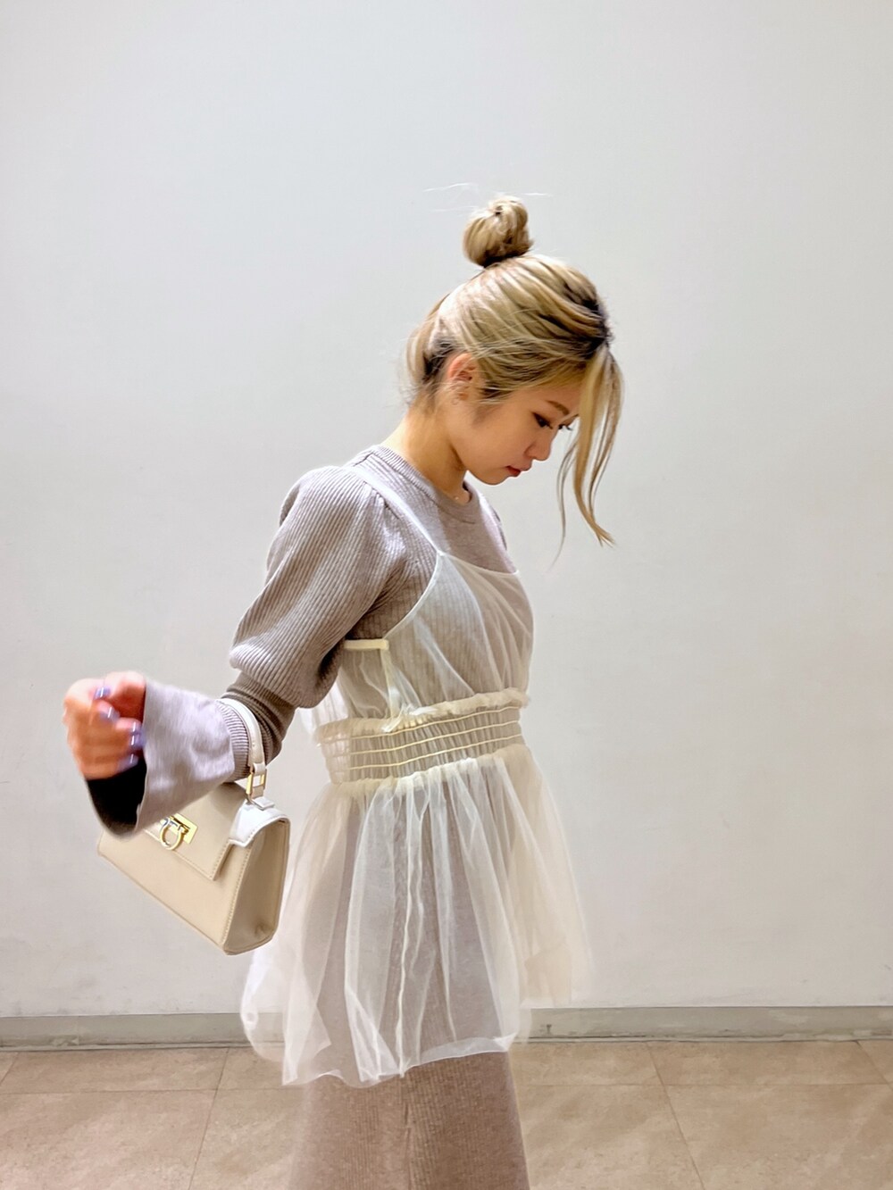 ホワイト系のショルダーバッグ、ブラック系のブーツ、ベージュ系のワンピースを着用したレディースの冬コーディネートの8枚目の写真