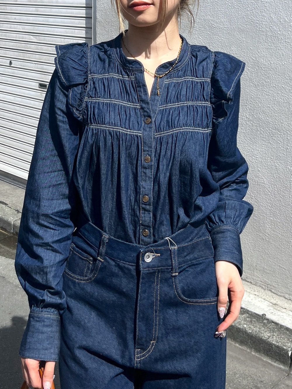 ブルー系のシャツ/ブラウス、ブルー系のデニムパンツ、ブラウン系のショルダーバッグを着用したレディースの春コーディネートの6枚目の写真