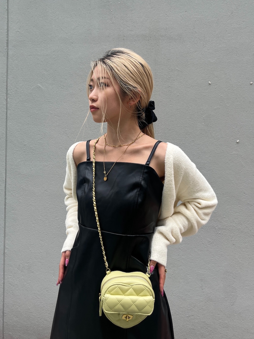 ブラック系のブーツ、ブラック系のワンピース、イエロー系のショルダーバッグを着用したレディースの秋コーディネートの5枚目の写真