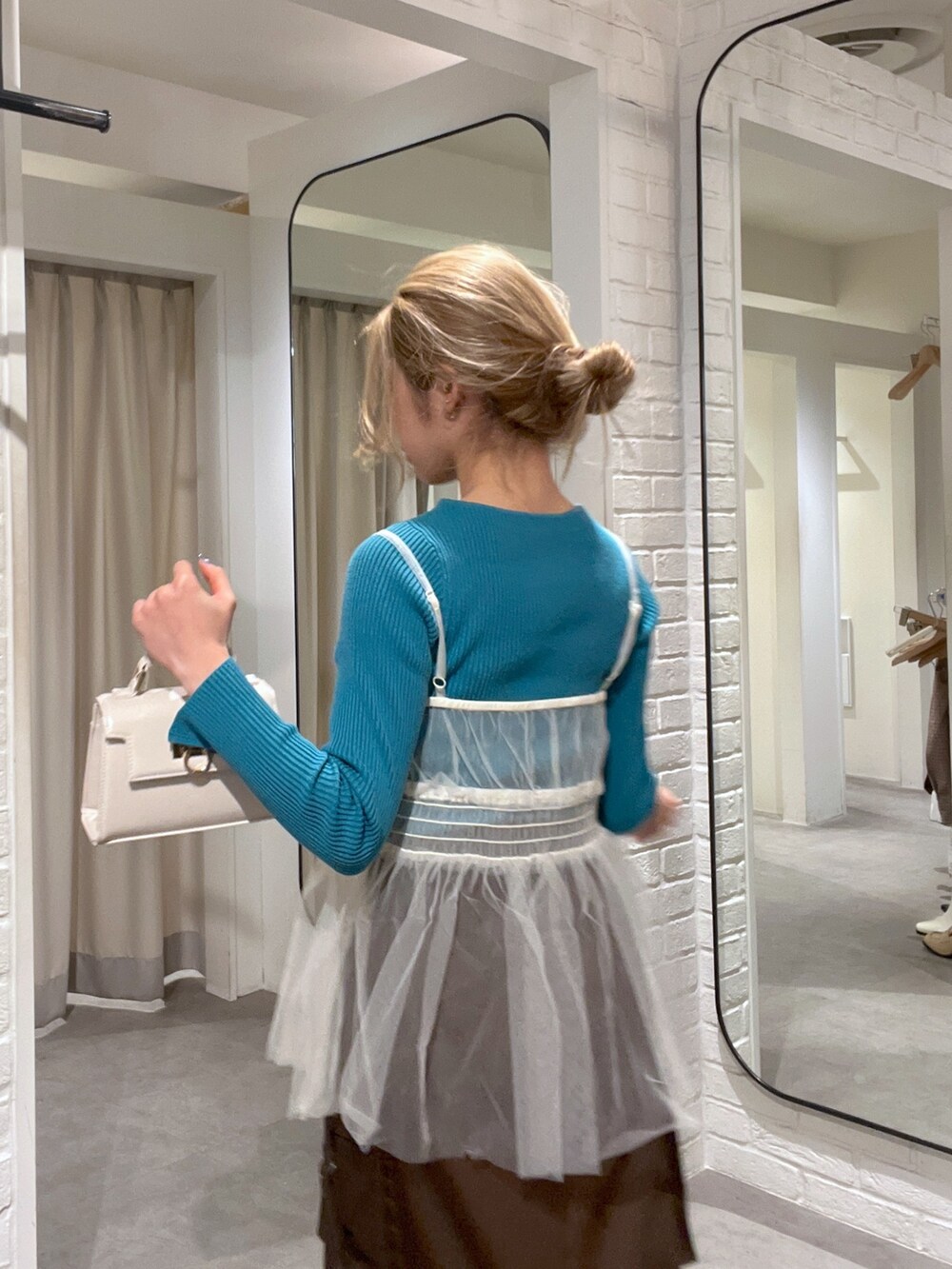 ブラウン系のスカート、ホワイト系のシャツ/ブラウス、ホワイト系のショルダーバッグを着用したレディースの冬コーディネートの5枚目の写真