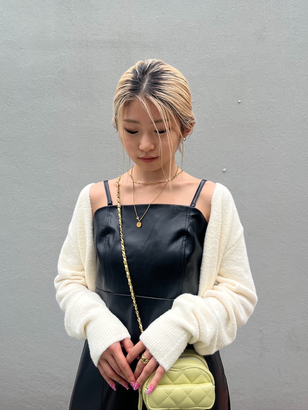 ブラック系のブーツ、ブラック系のワンピース、イエロー系のショルダーバッグを着用したレディースの秋コーディネートの4枚目の写真