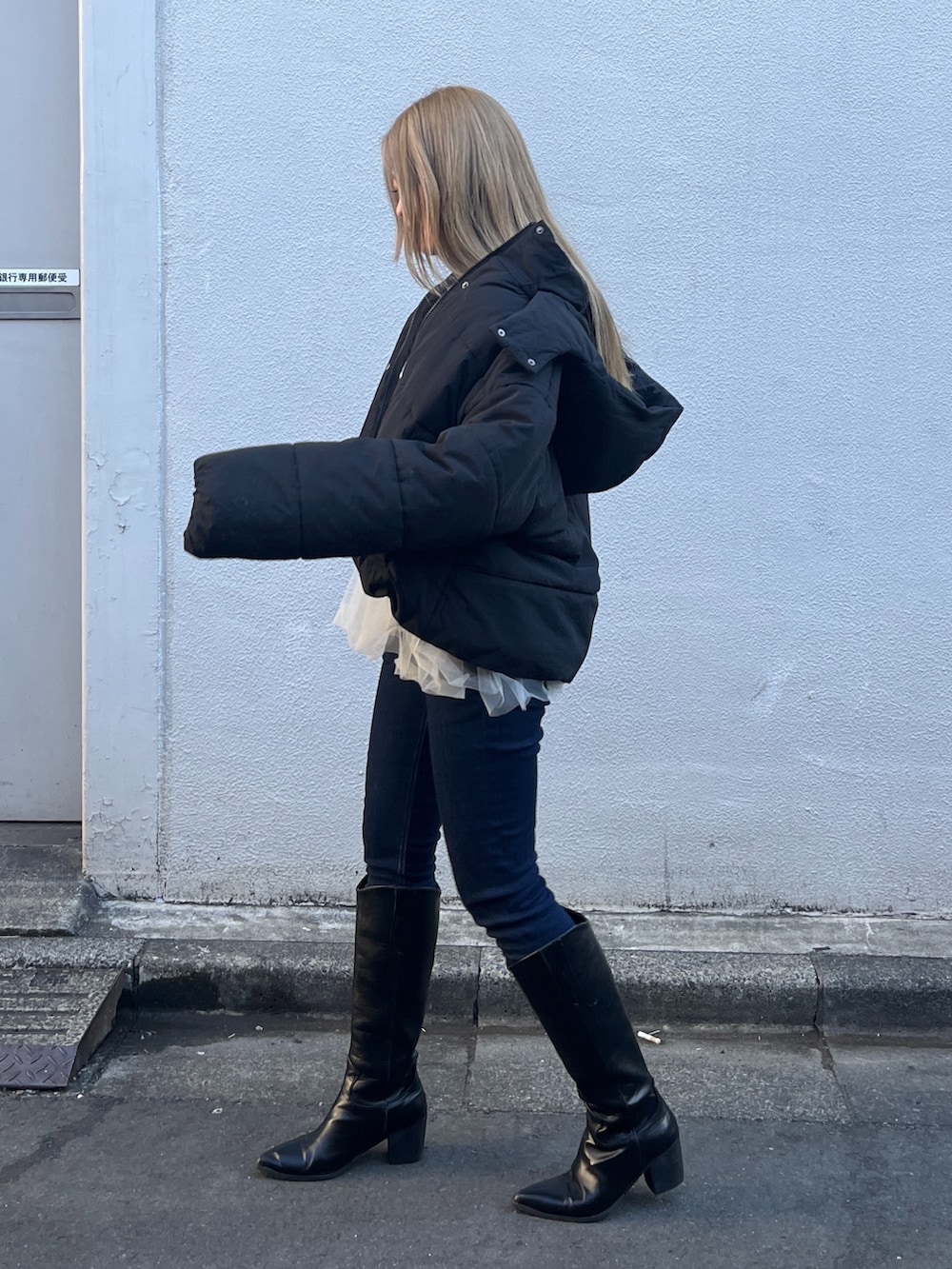 ホワイト系のシャツ/ブラウス、グレー系のニット/セーター、ブルー系のデニムパンツを着用したレディースの冬コーディネートの3枚目の写真