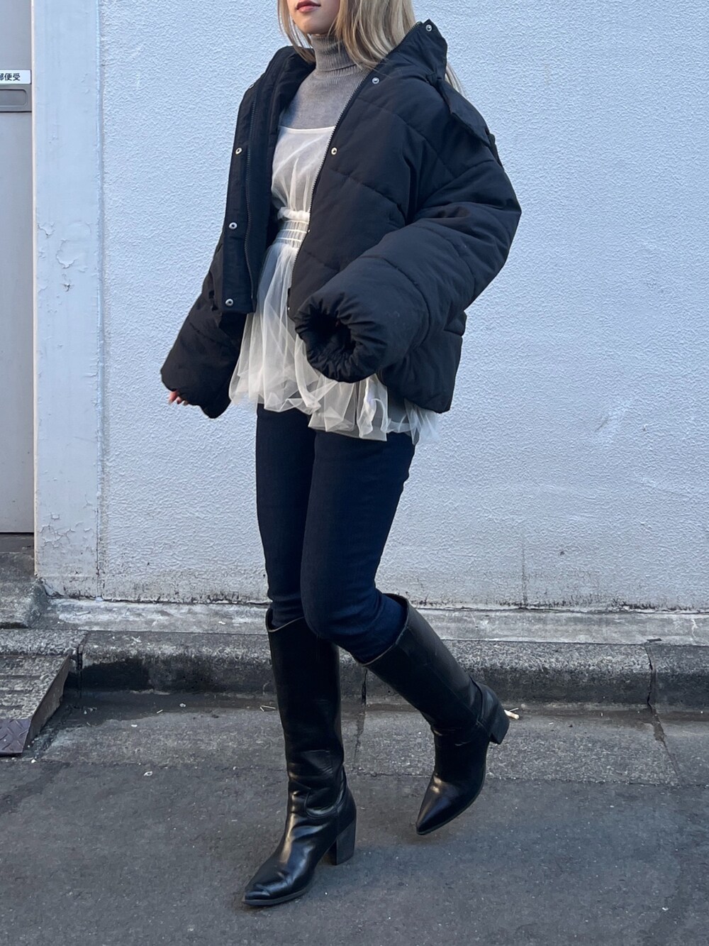 ホワイト系のシャツ/ブラウス、グレー系のニット/セーター、ブルー系のデニムパンツを着用したレディースの冬コーディネートの6枚目の写真