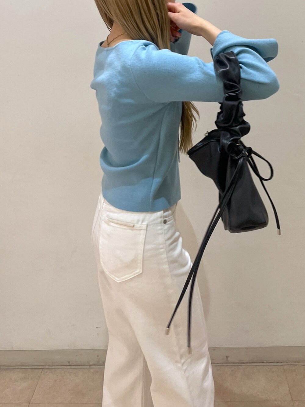 ホワイト系のデニムパンツ、ブラック系のショルダーバッグ、ブラック系のパンプスを着用したレディースの春コーディネートの6枚目の写真