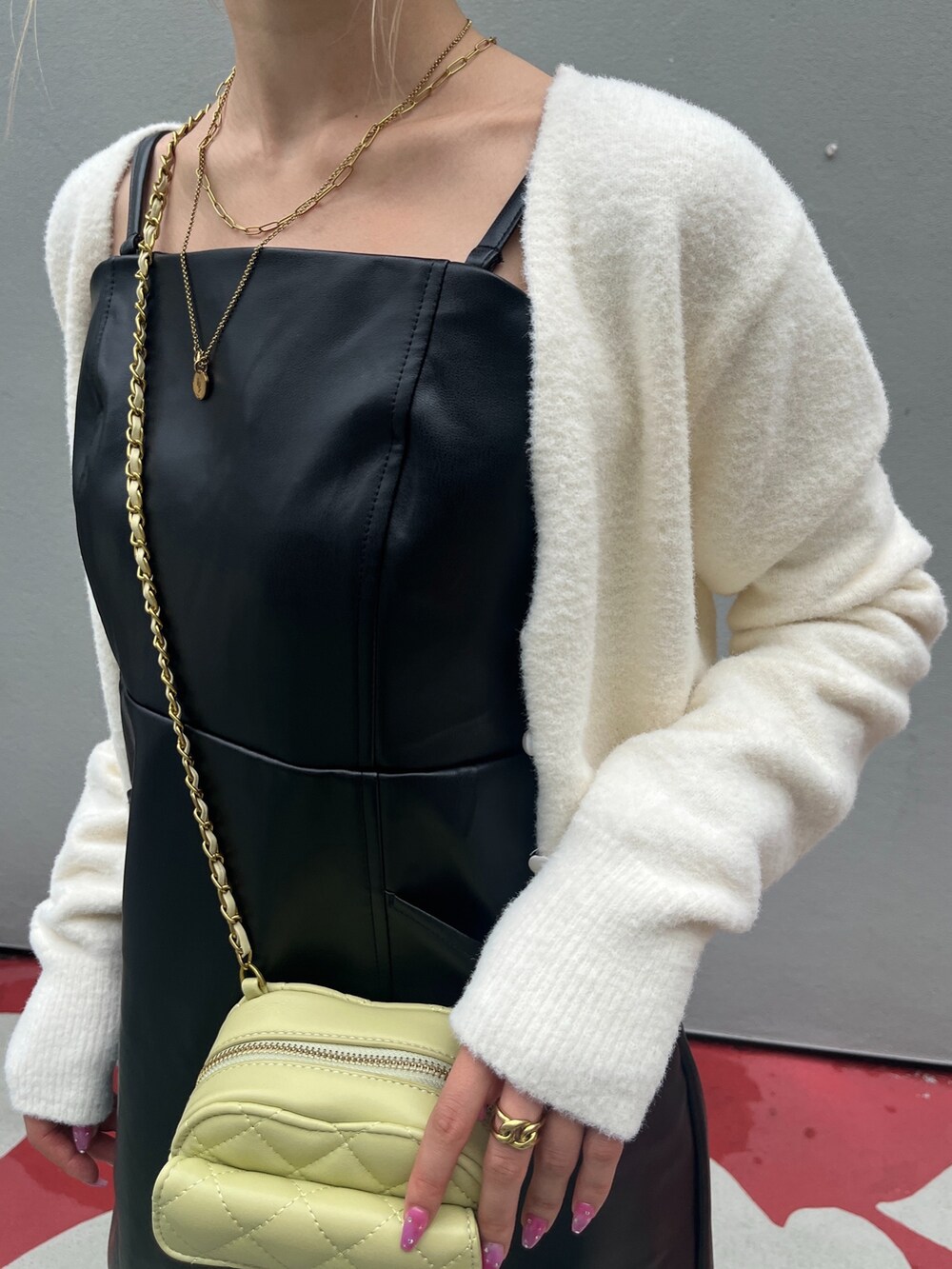 ブラック系のブーツ、ブラック系のワンピース、イエロー系のショルダーバッグを着用したレディースの秋コーディネートの8枚目の写真