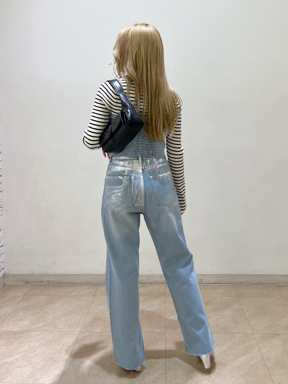 ブルー系のベスト、ホワイト系のニット/セーター、ブラック系のショルダーバッグを着用したレディースの冬コーディネートの5枚目の写真