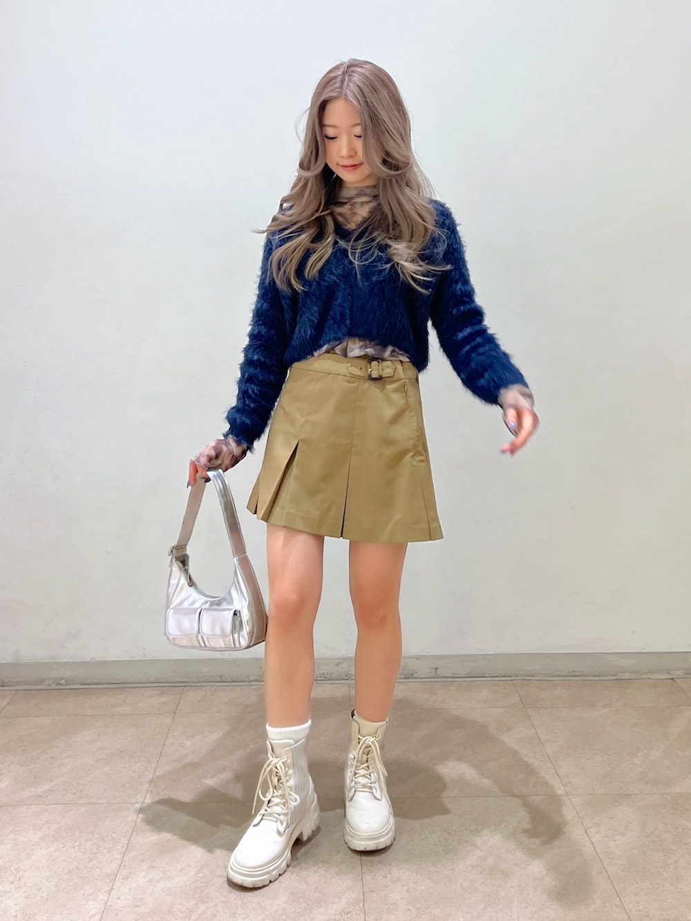 グレー系のTシャツ/カットソー、シルバー系のショルダーバッグ、ブルー系のカーディガン/ボレロを着用したレディースの冬コーディネートの2枚目の写真