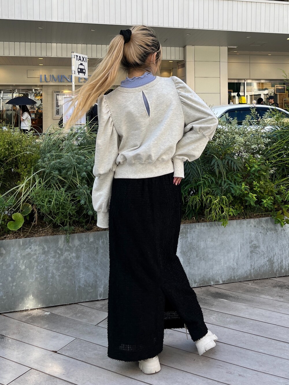 ホワイト系のスウェット、ホワイト系のブーツ、ブラック系のスカートを着用したレディースの秋コーディネートの5枚目の写真
