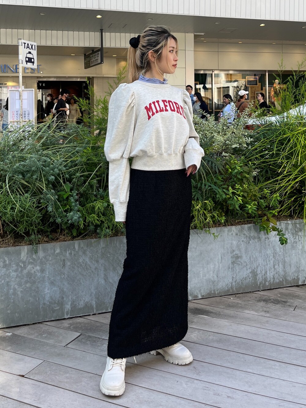 ホワイト系のスウェット、ホワイト系のブーツ、ブラック系のスカートを着用したレディースの秋コーディネートの6枚目の写真