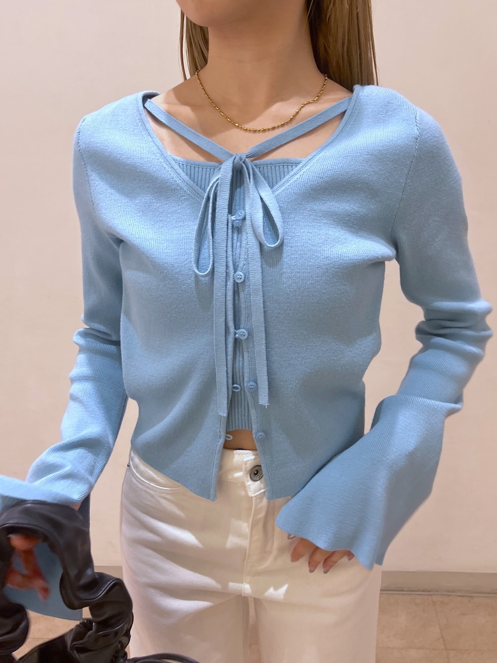 ホワイト系のデニムパンツ、ブラック系のショルダーバッグ、ブラック系のパンプスを着用したレディースの春コーディネートの7枚目の写真