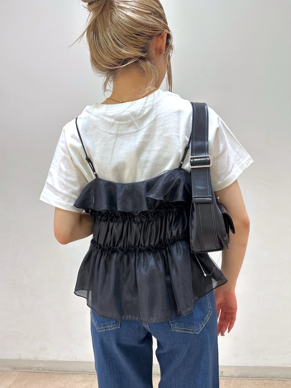 ブラック系のショルダーバッグ、ブラック系のシャツ/ブラウス、ホワイト系のTシャツ/カットソーを着用したレディースの春コーディネートの7枚目の写真