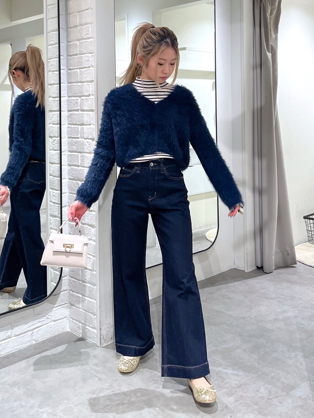 ホワイト系のニット/セーター、ブルー系のカーディガン/ボレロ、ホワイト系のショルダーバッグを着用したレディースの冬コーディネートの2枚目の写真