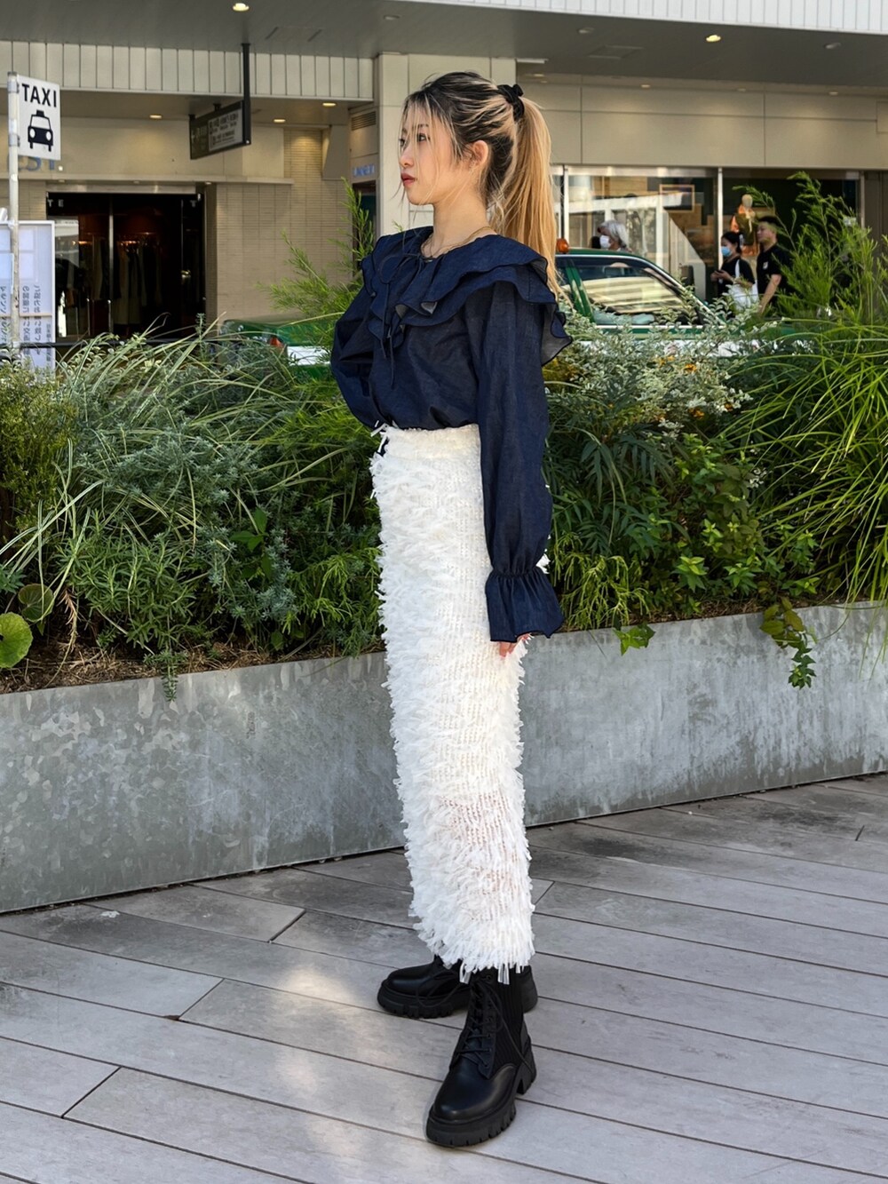 ホワイト系のスカート、ブルー系のシャツ/ブラウス、ブラック系のブーツを着用したレディースの秋コーディネートの2枚目の写真