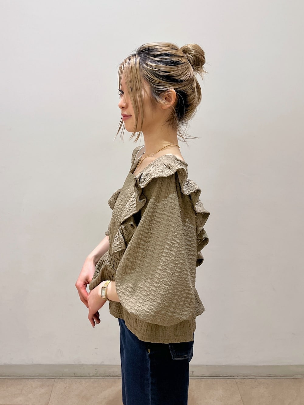 ブラウン系のシャツ/ブラウス、ブルー系のデニムパンツ、ゴールド系のパンプスを着用したレディースの春コーディネートの6枚目の写真