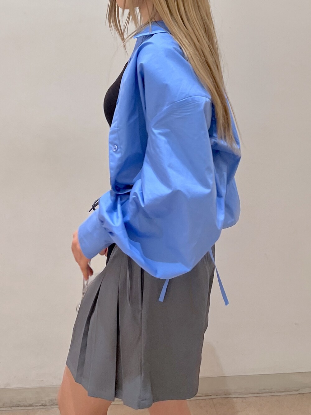 ブルー系のシャツ/ブラウス、グレー系のスカート、シルバー系のショルダーバッグを着用したレディースの春コーディネートの6枚目の写真