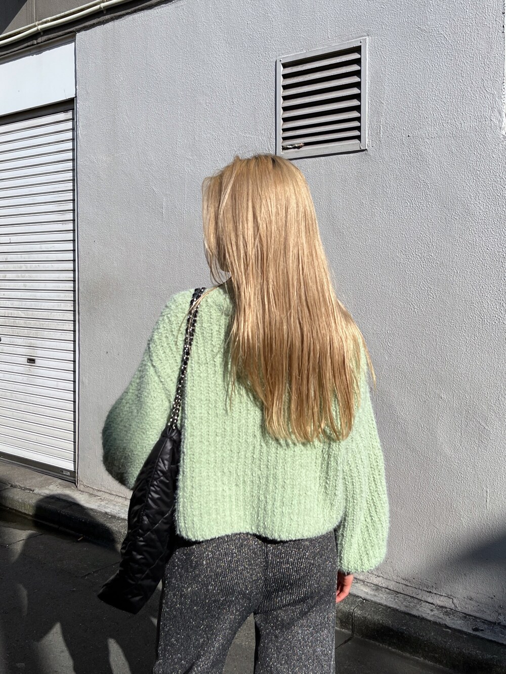 ブラック系のブーツ、ブラック系のその他パンツ、グリーン系のニット/セーターを着用したレディースの冬コーディネートの8枚目の写真