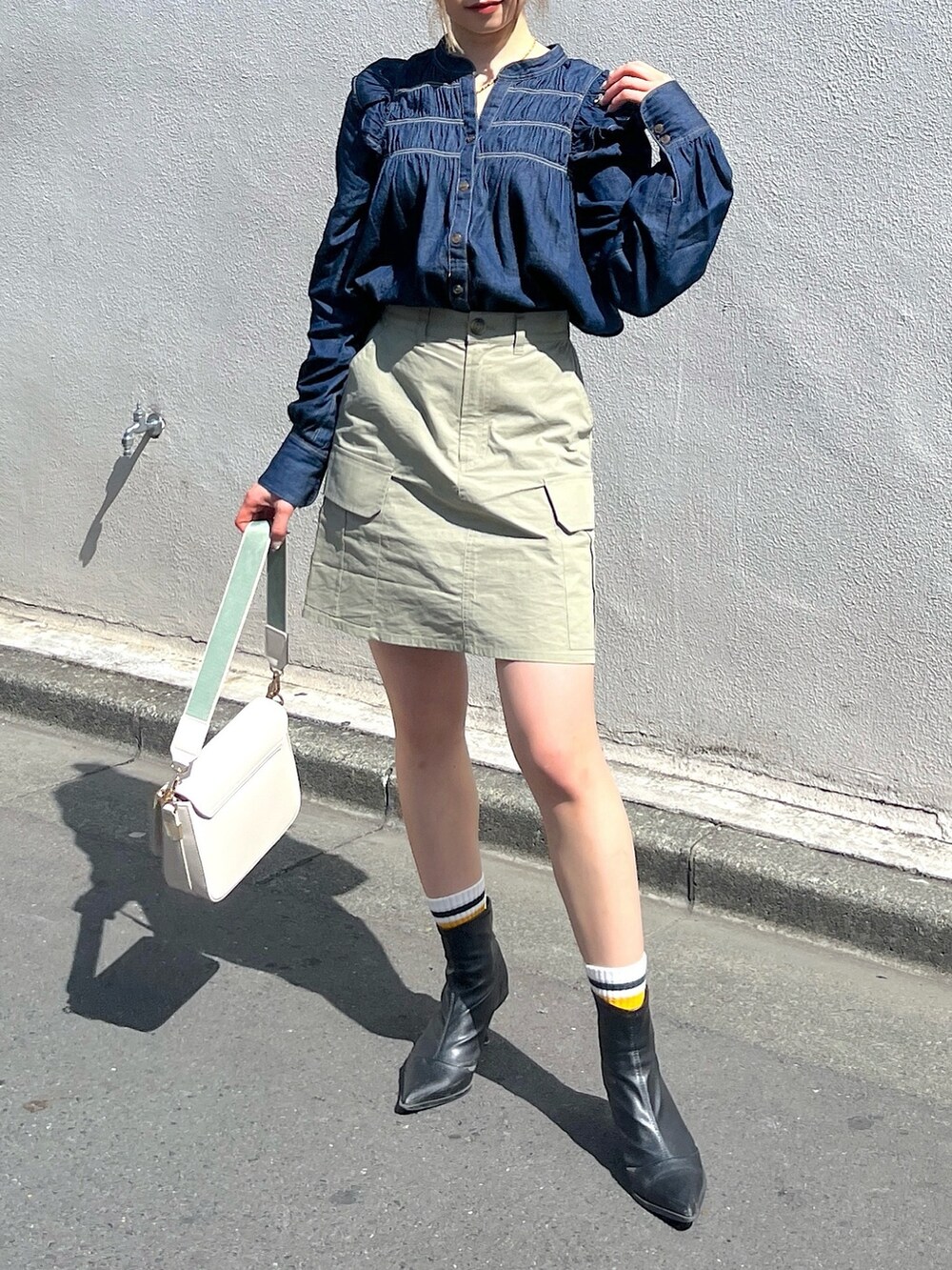 グリーン系のスカート、ホワイト系のショルダーバッグ、ブルー系のシャツ/ブラウスを着用したレディースの春コーディネートの5枚目の写真