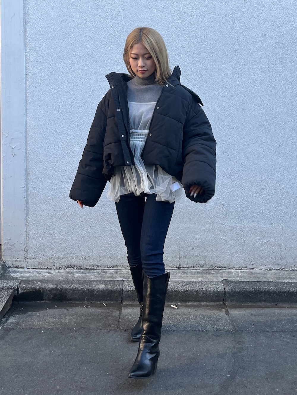 ホワイト系のシャツ/ブラウス、グレー系のニット/セーター、ブルー系のデニムパンツを着用したレディースの冬コーディネートの2枚目の写真