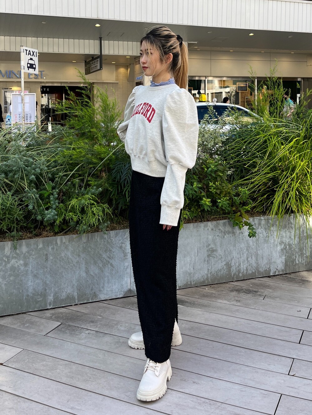 ホワイト系のスウェット、ホワイト系のブーツ、ブラック系のスカートを着用したレディースの秋コーディネートの3枚目の写真