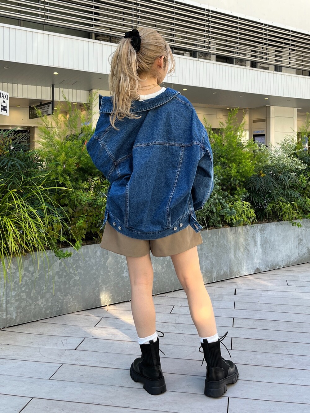 ブルー系のデニムジャケット、ホワイト系のTシャツ/カットソー、ブラック系のボディバッグ/ウエストポーチを着用したレディースの秋コーディネートの6枚目の写真