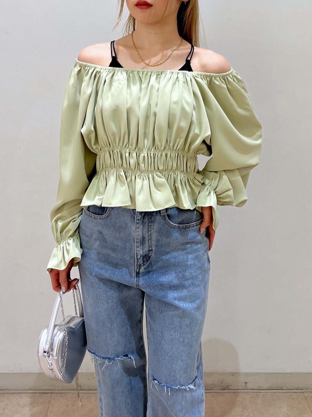 グリーン系のシャツ/ブラウス、シルバー系のショルダーバッグ、ブルー系のデニムパンツを着用したレディースの春コーディネートの9枚目の写真