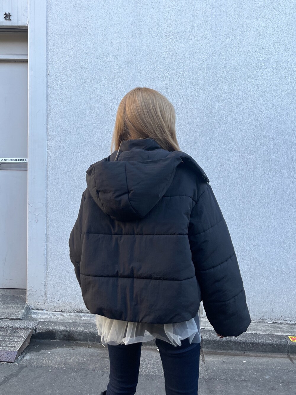 ホワイト系のシャツ/ブラウス、グレー系のニット/セーター、ブルー系のデニムパンツを着用したレディースの冬コーディネートの10枚目の写真