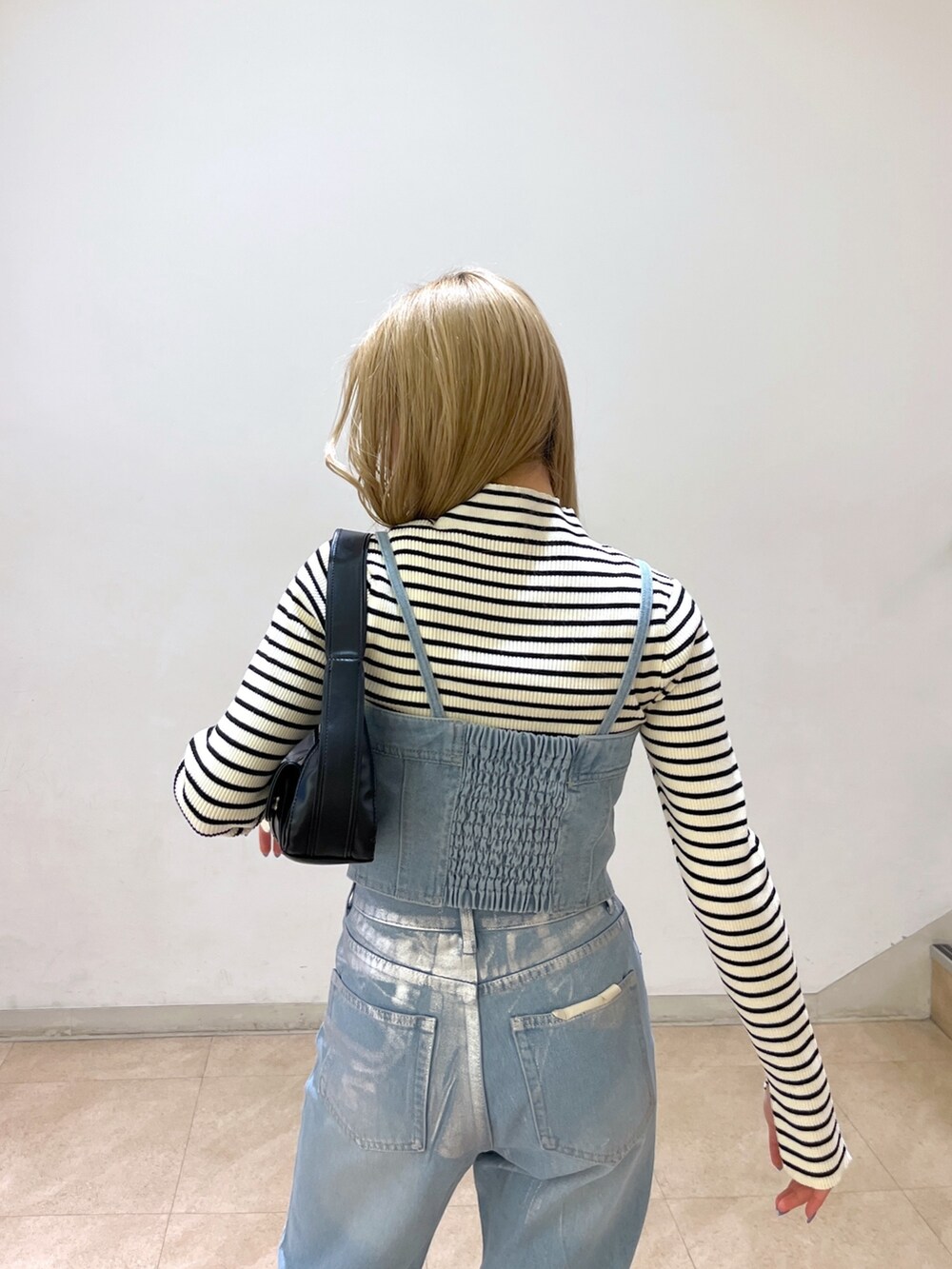 ブルー系のベスト、ホワイト系のニット/セーター、ブラック系のショルダーバッグを着用したレディースの冬コーディネートの8枚目の写真