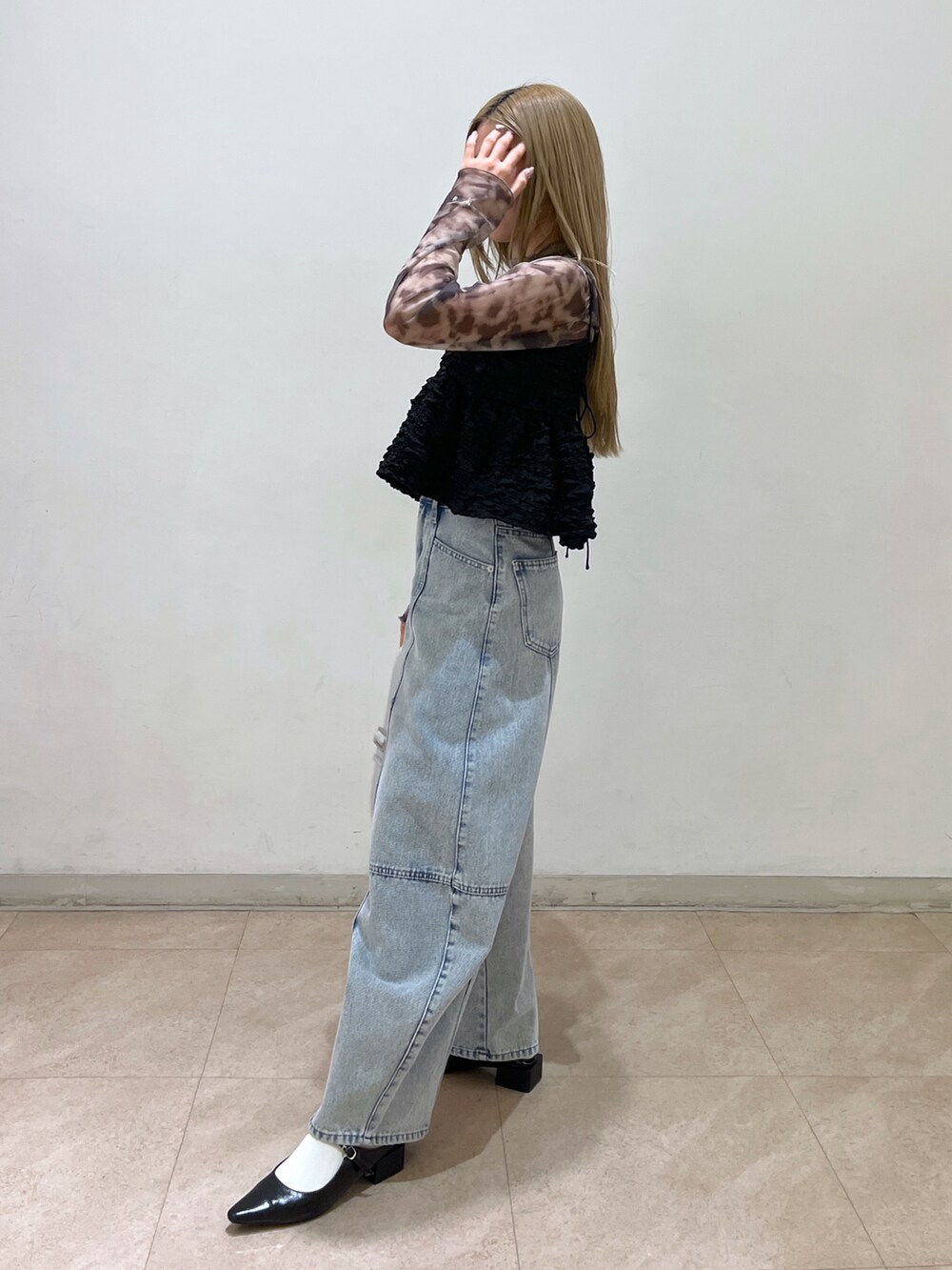 ブラック系のシャツ/ブラウス、シルバー系のショルダーバッグ、ブルー系のデニムパンツを着用したレディースの春コーディネートの3枚目の写真