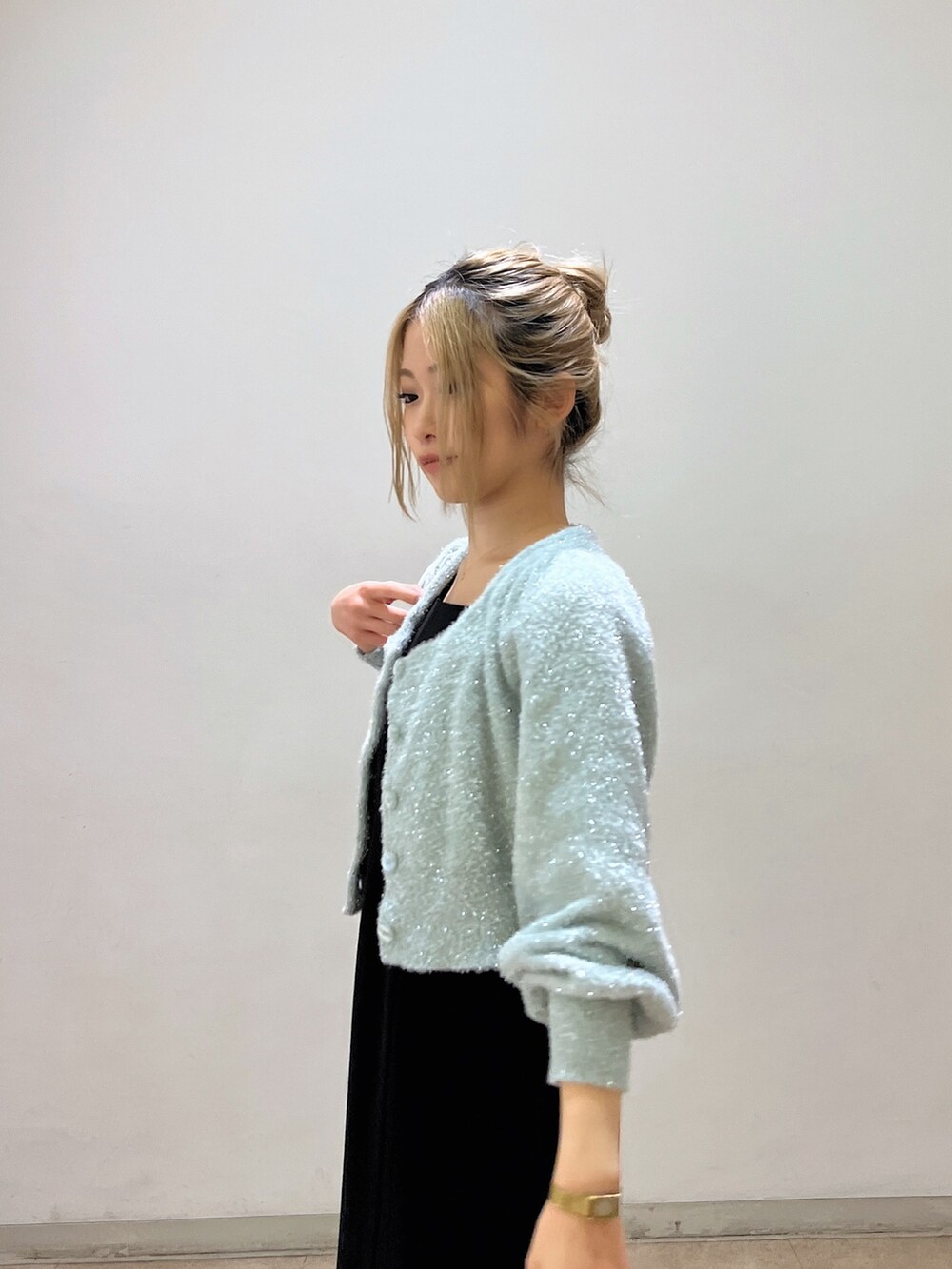 グリーン系のカーディガン/ボレロ、ホワイト系のショルダーバッグ、ブラック系のワンピースを着用したレディースの冬コーディネートの8枚目の写真