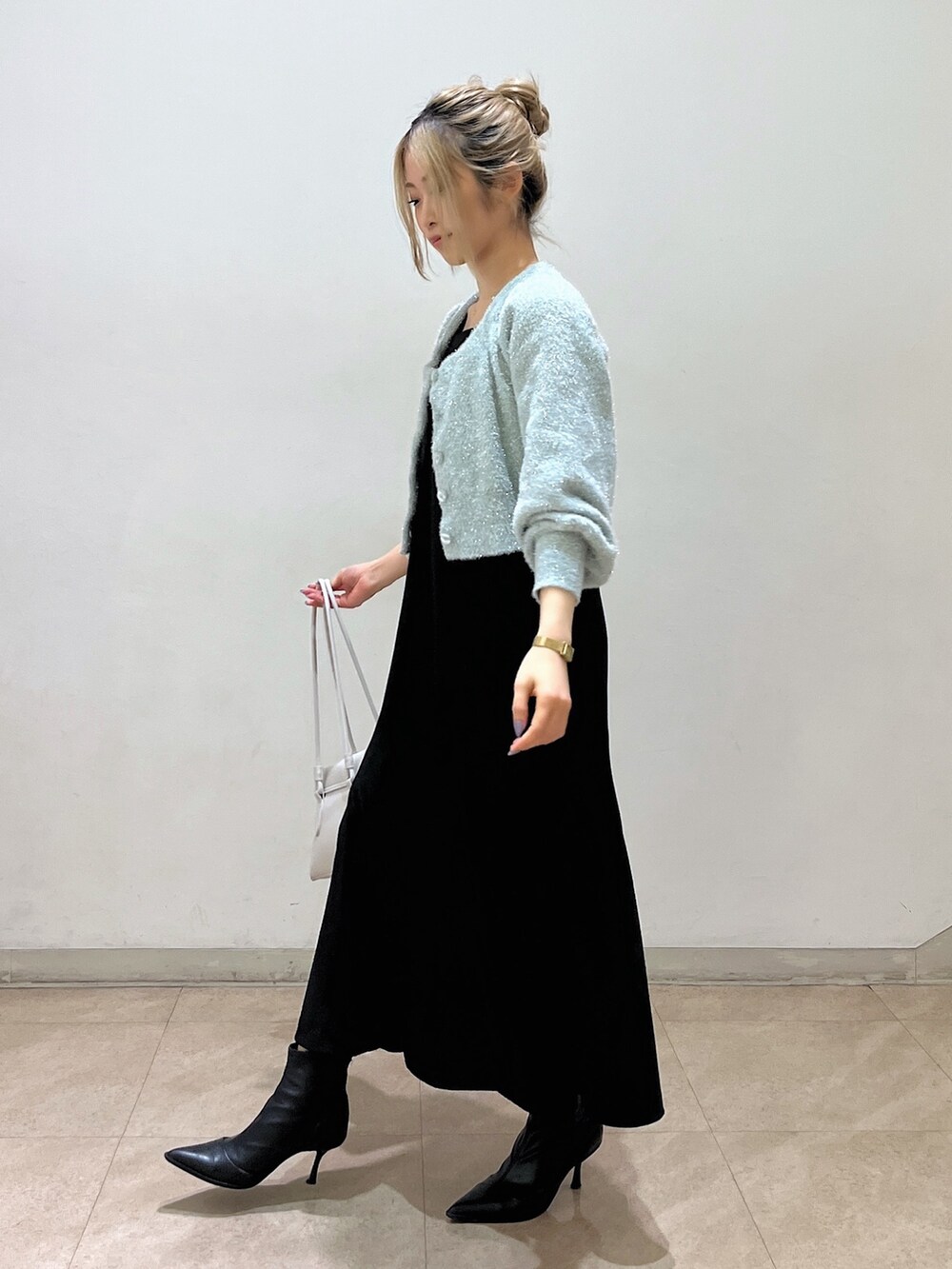 グリーン系のカーディガン/ボレロ、ホワイト系のショルダーバッグ、ブラック系のワンピースを着用したレディースの冬コーディネートの4枚目の写真