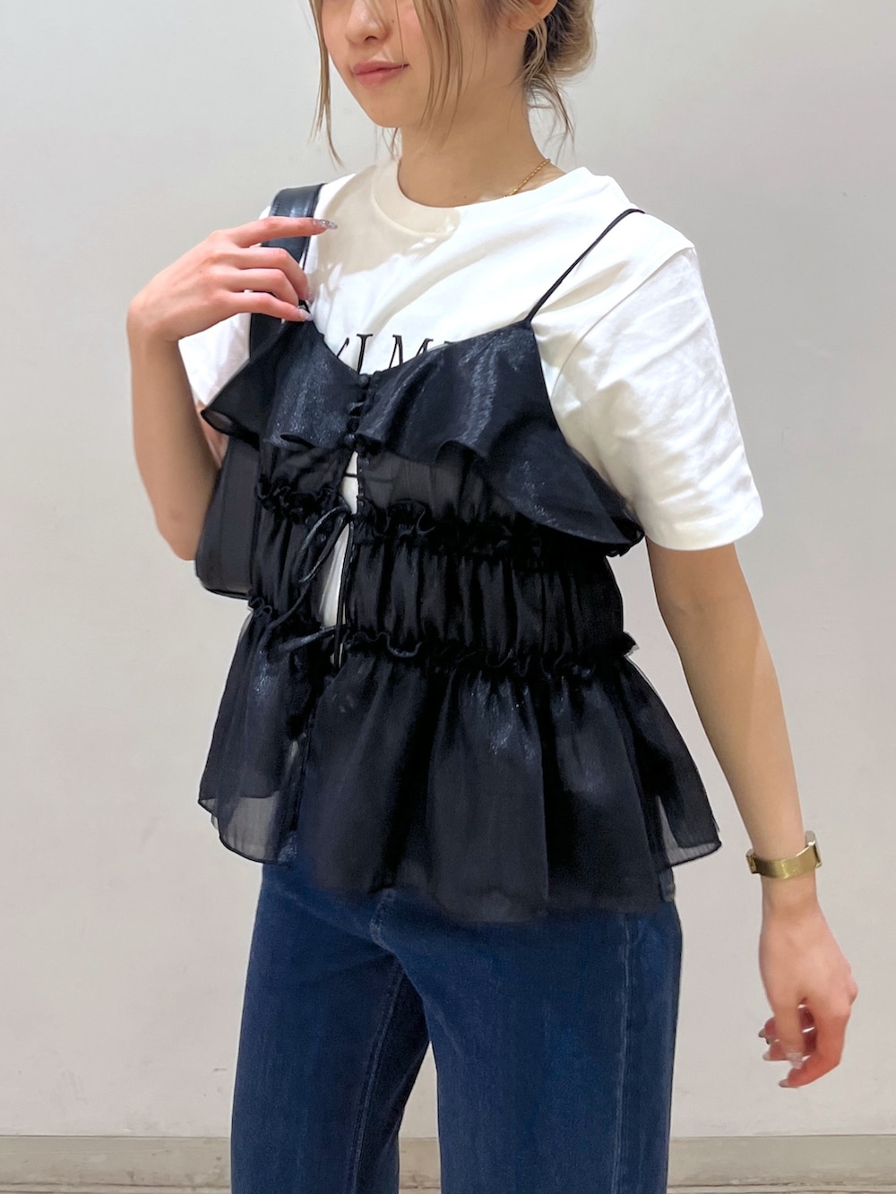 ブラック系のショルダーバッグ、ブラック系のシャツ/ブラウス、ホワイト系のTシャツ/カットソーを着用したレディースの春コーディネートの5枚目の写真